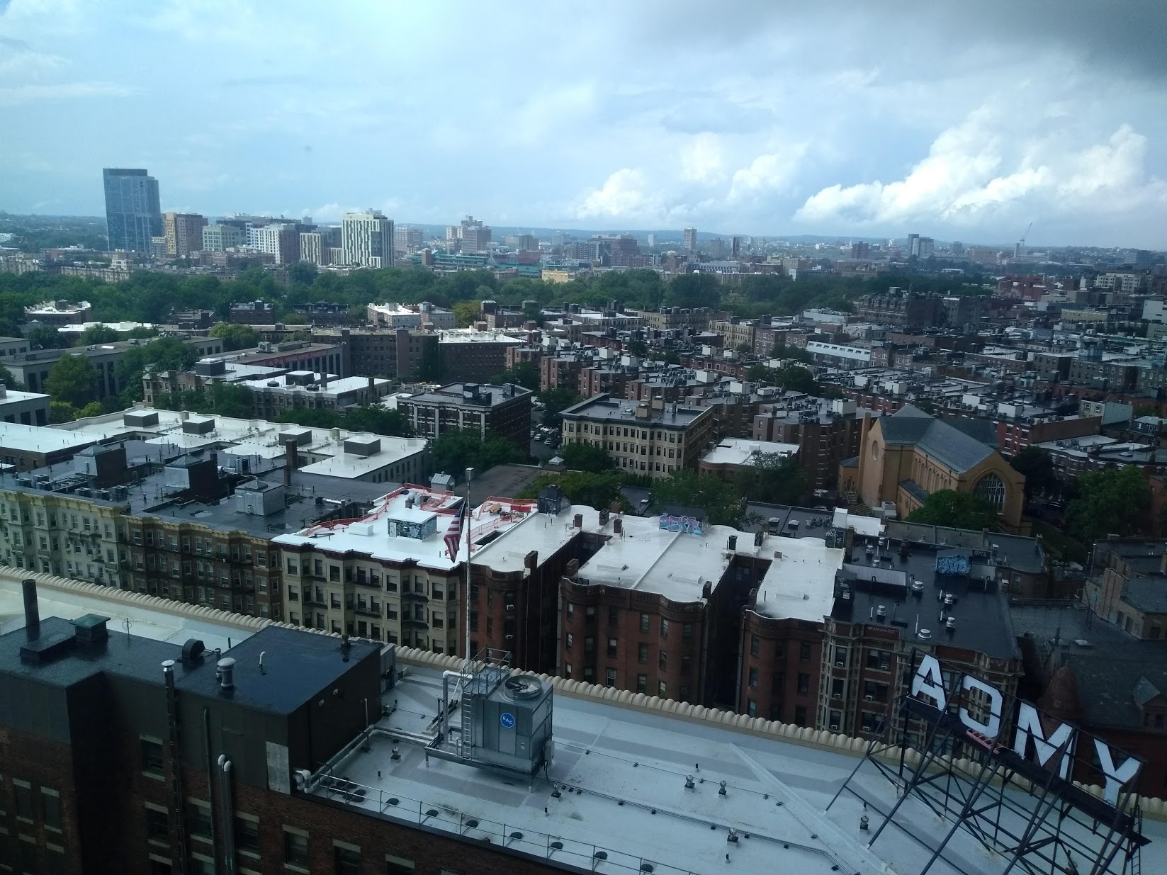 Picture: A view of Boston from the author’s residence hall room during summer 2018. The green bleachers in the center, behind the treeline, are Fenway Park.